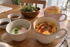 マグカップで作った温泉たまご・オムライス・スポンジケーキが並んだ食卓